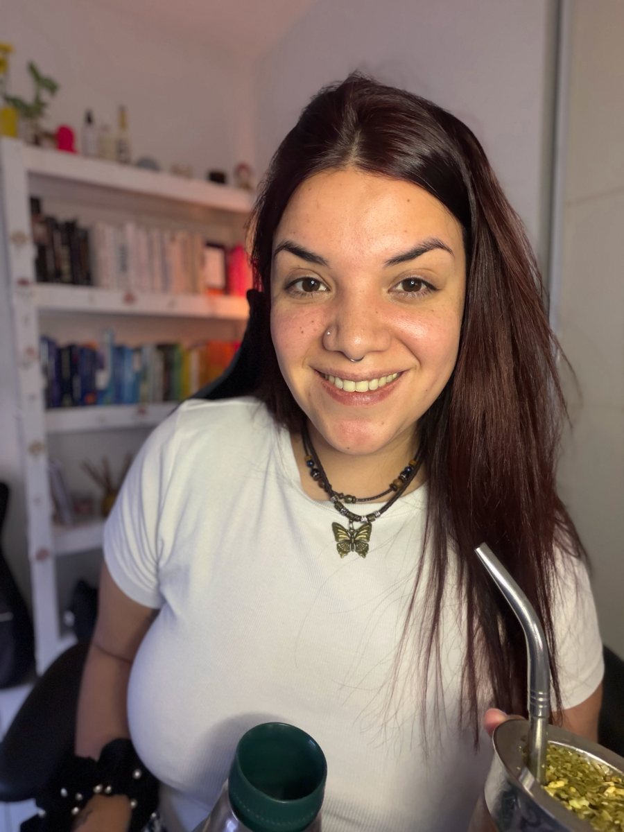 María Magdalena sonriendo con un mate en su espacio, con un dije de mariposa